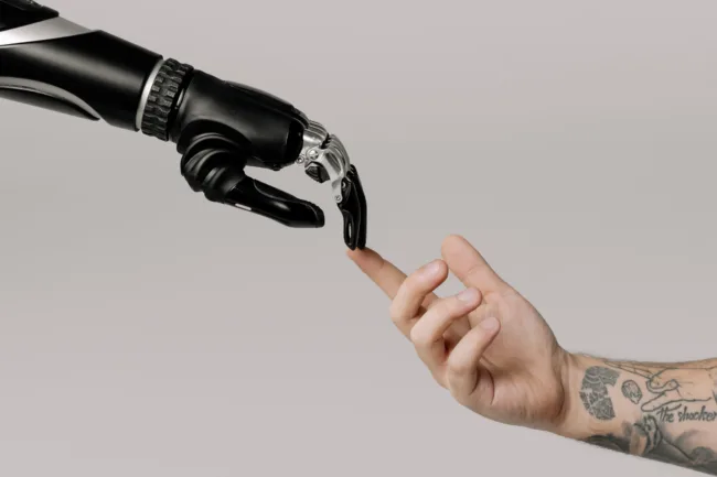 Robotic arm reaching for a human arm and touching at the fingertips